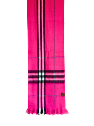 A bright pink scarf with a classic plaid pattern featuring black, white, and light blue stripes, hanging from a wooden hanger against a white background.