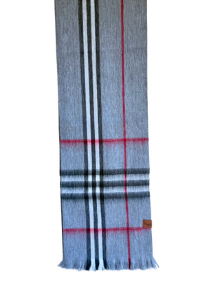 A gray plaid scarf with black, white, and red stripes, hanging from a wooden hanger against a white background.